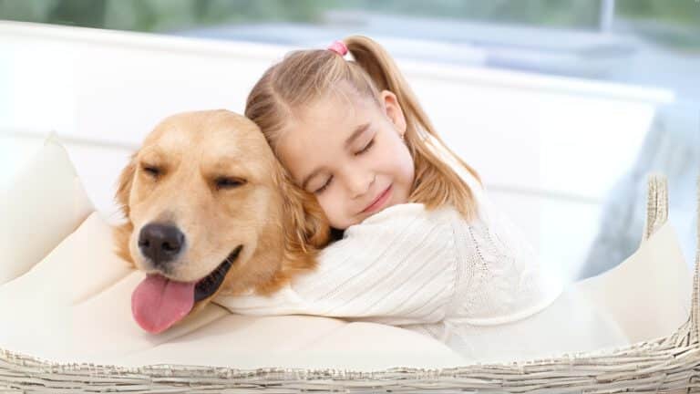 Kind drückt Hund liebevoll an sich